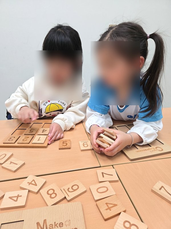 숫자 퍼즐 교구 활동에 몰입한 아이들
